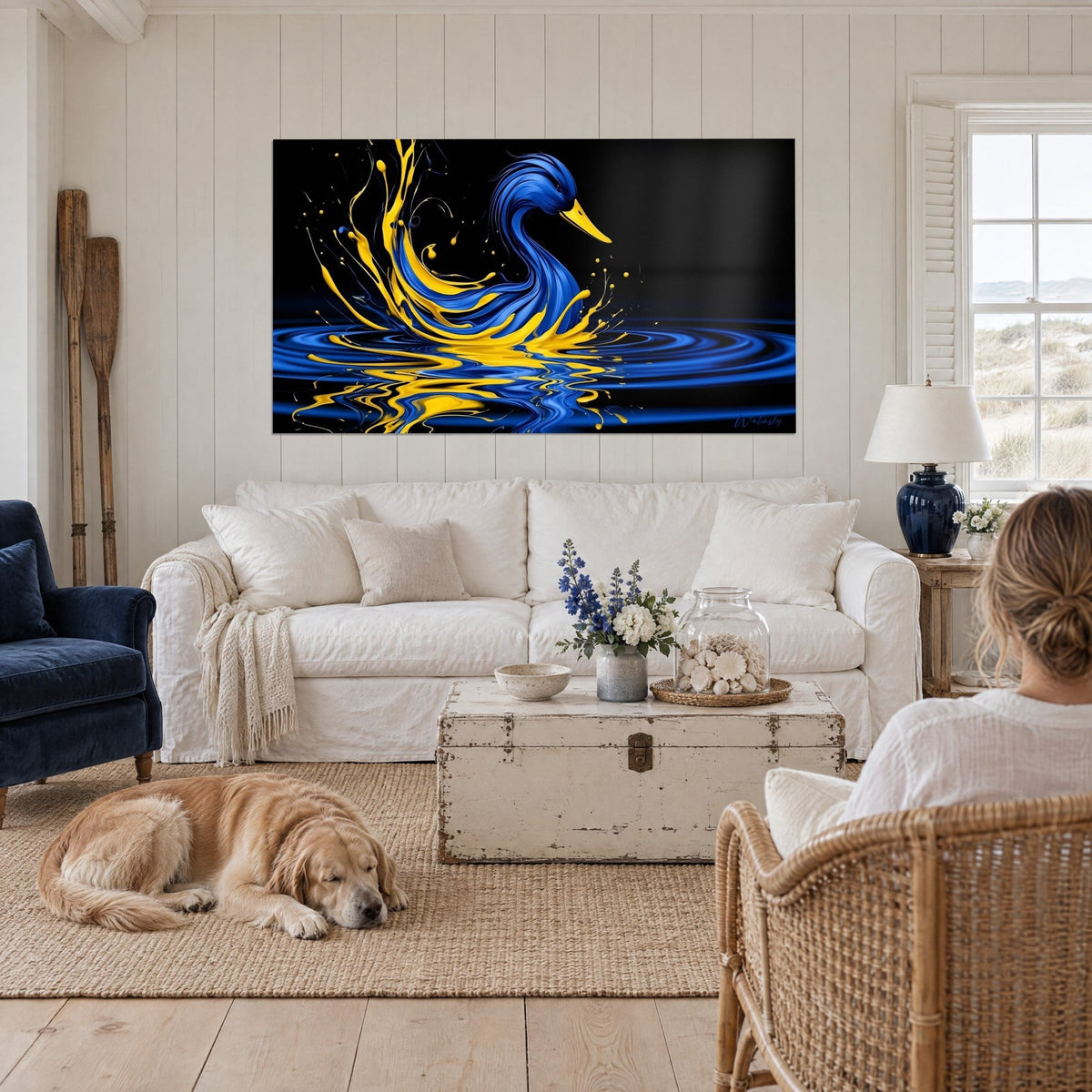 Tableau canard bleu cobalt aux éclaboussures jaunes, anneaux sur eau noire, au-dessus d'un canapé dans un salon lumineux