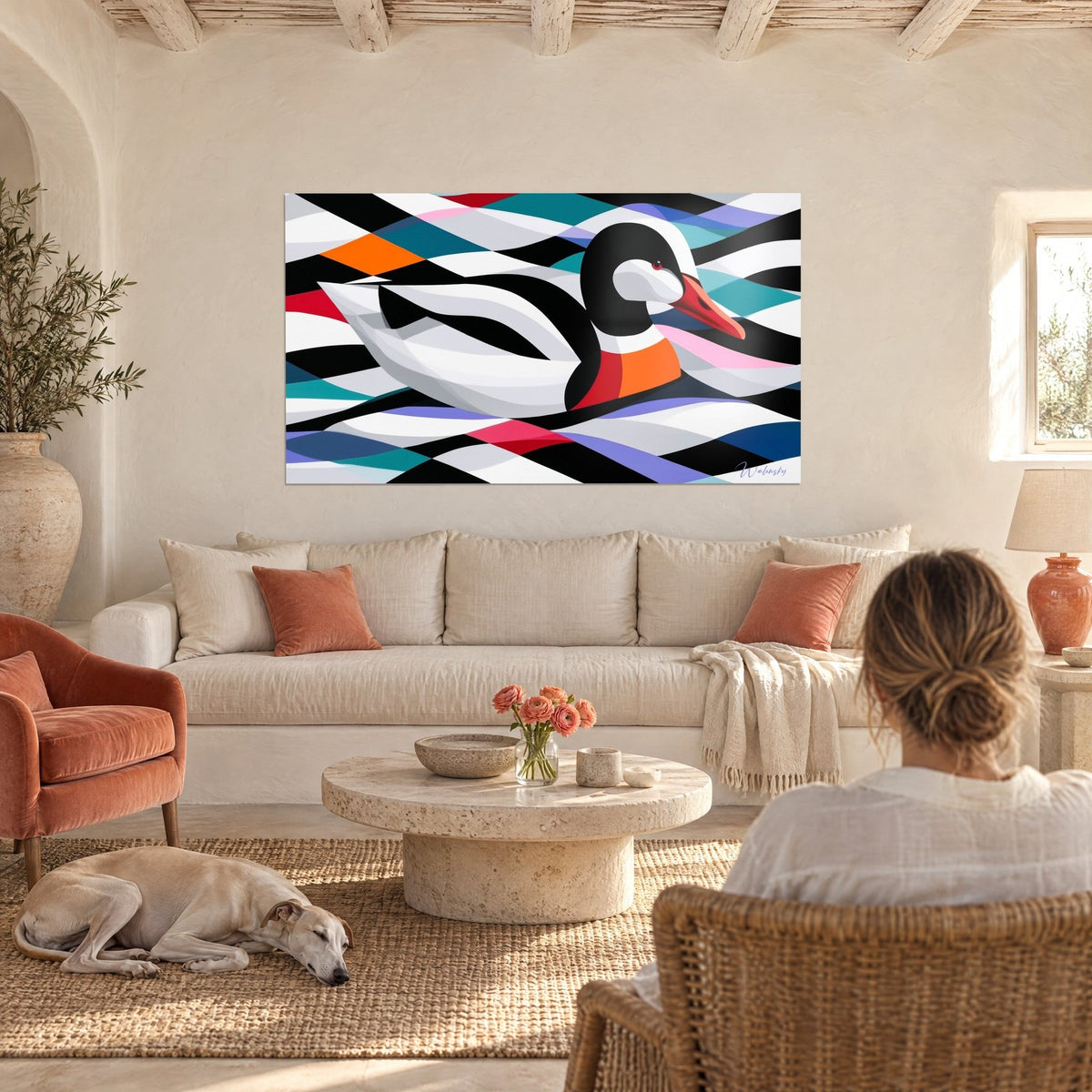 Tableau canard noir et blanc au bec orangé, éclats rouges et turquoise, avec une femme et un lévrier, au-dessus d'un canapé dans un salon lumineux