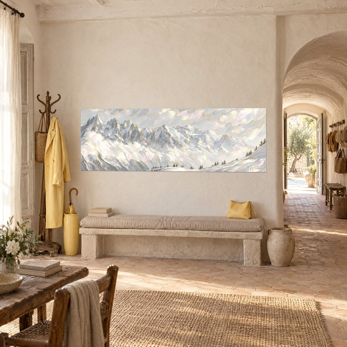 Wall art of a chain of frosted peaks in white and gold, dark fir trees in the foreground, on a cream wall above a stone bench