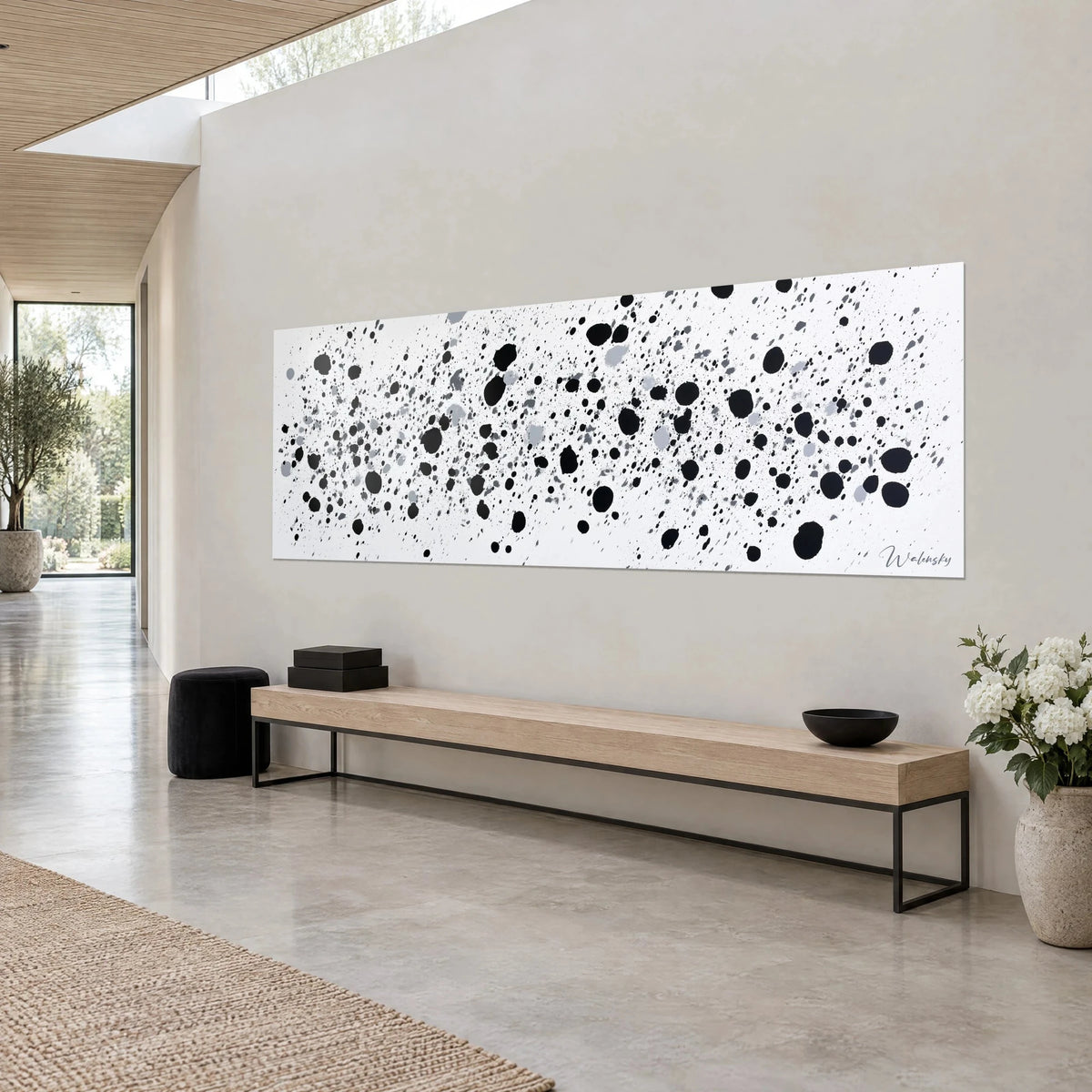 Gemälde mit einer Wolke aus schwarzen und grauen Farbspritzern auf Weiß, breites Panoramaformat, Dreiviertelansicht auf eine helle graue Wand