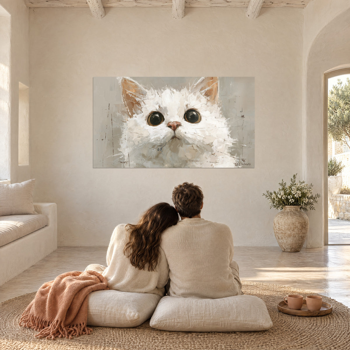 Tableau regard de chaton écarquillé, pelage blanc et beige, fond grège, devant un couple enlacé sous un plaid corail