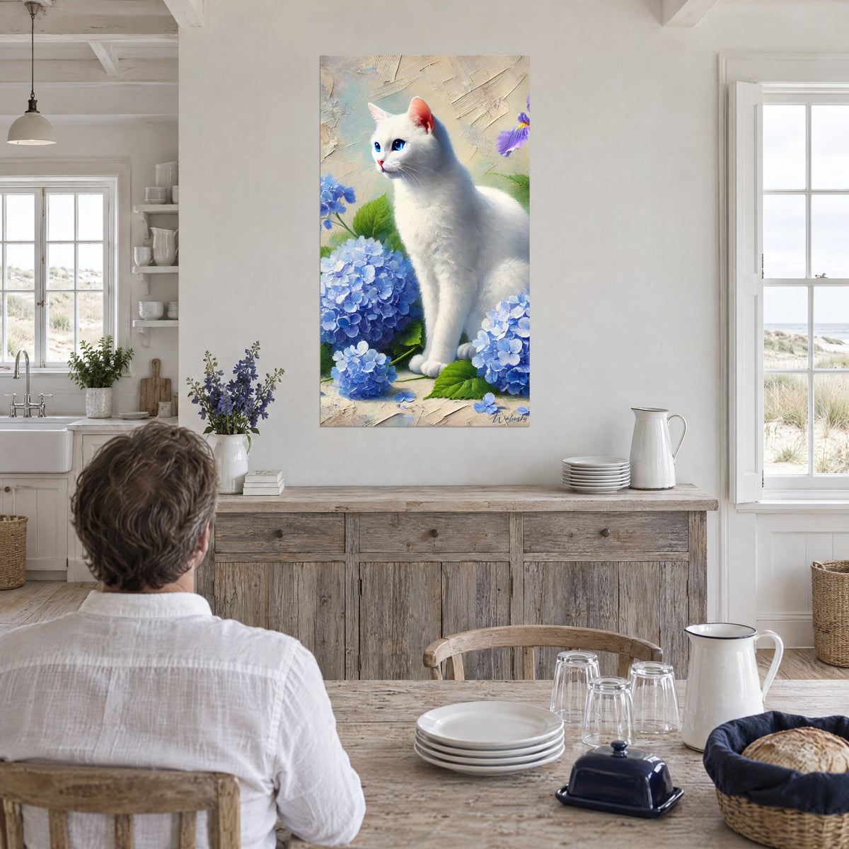 Cuadro gatito blanco de iris azules, flores de hortensia azul cielo y fondo beige texturizado, en una cocina junto al mar