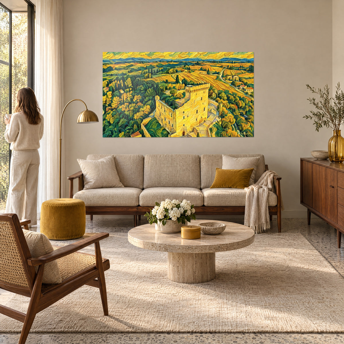 Wall art medieval castle in golden yellow stone, thick brushstrokes, green vineyards and ochre fields, a woman seen from behind above a sofa in a bright living room