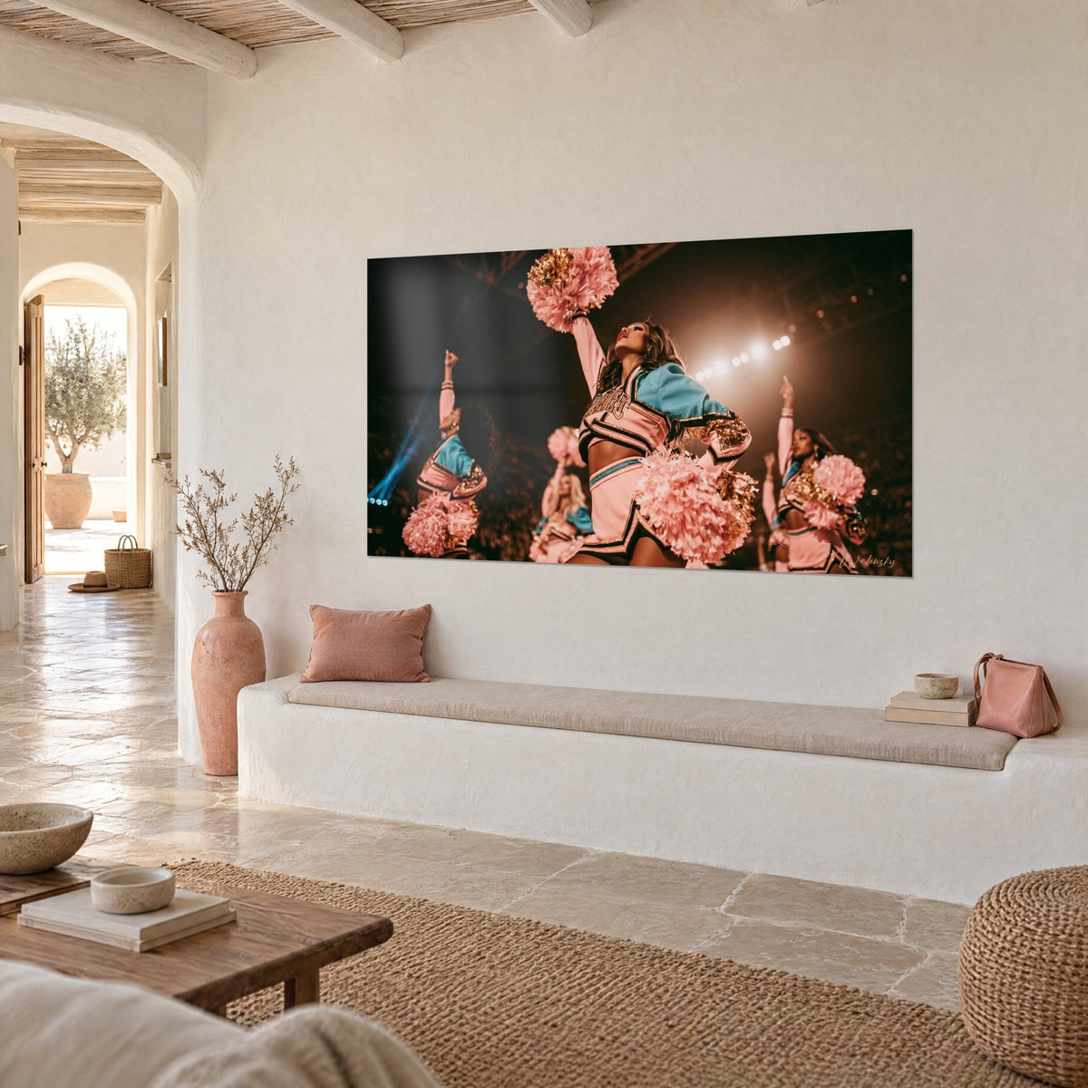 Wall art cheerleaders in powder pink and turquoise outfits, white stadium lights, on a cream wall of a Mediterranean home