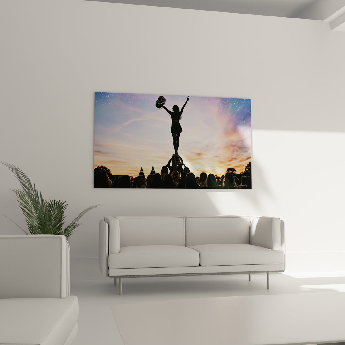 Jeune cheerleader debout en équilibre, silhouette sombre sur ciel orange, au-dessus d'un canapé dans un salon lumineux