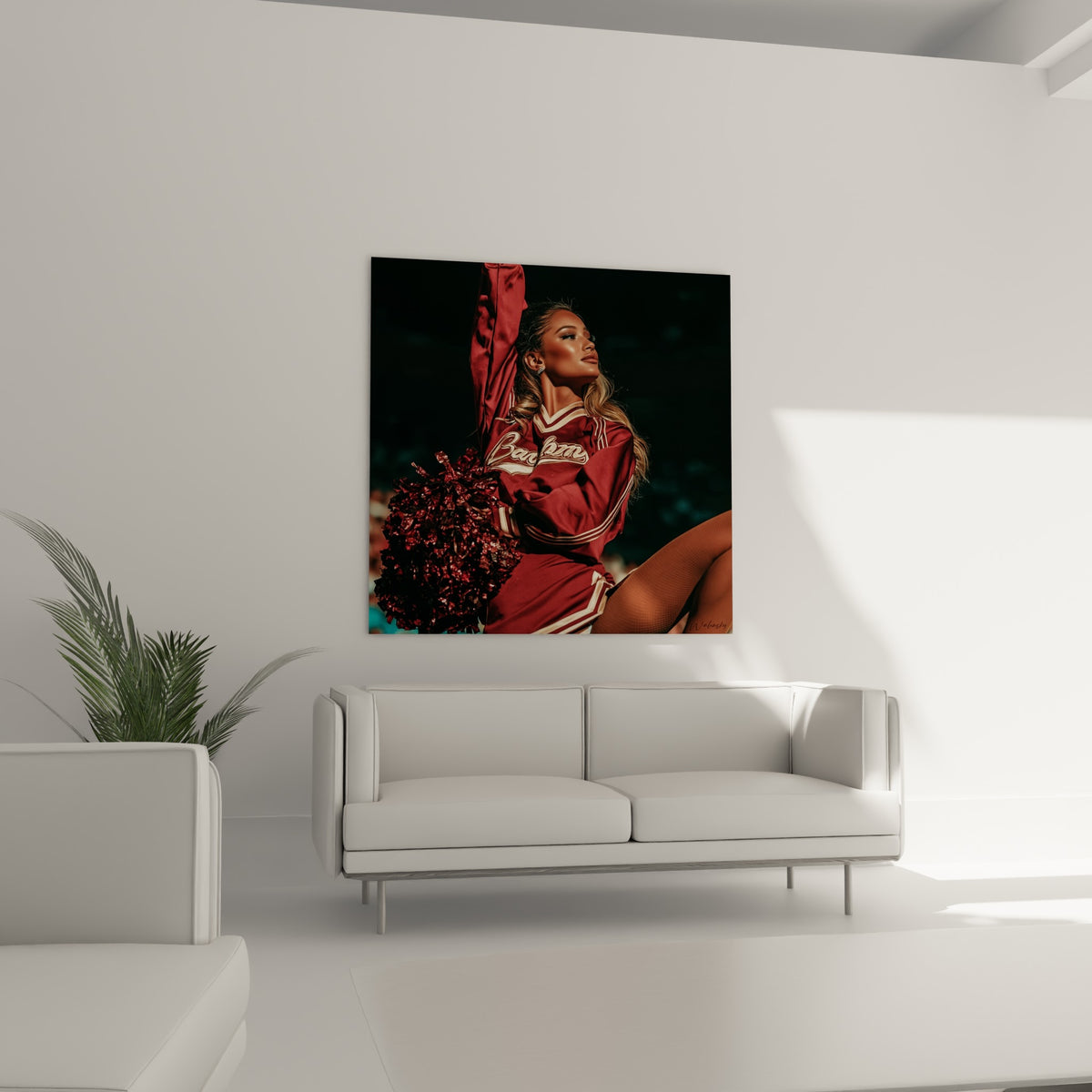 Portrait sportif bordeaux et doré d'une pom-pom girl, disposé au-dessus d'un canapé dans un salon lumineux