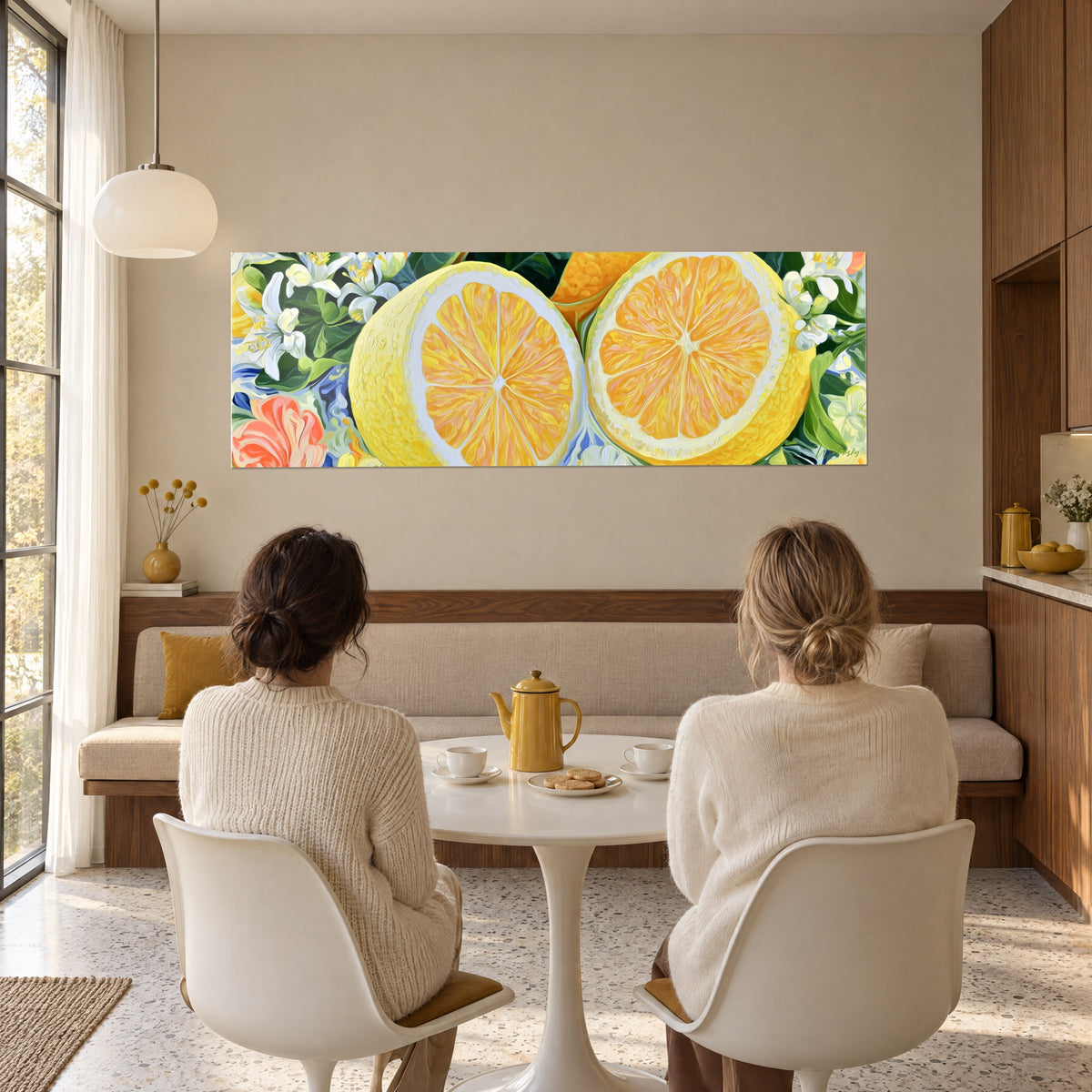 Wall art of white orange blossoms around two citrus fruits in lemon and sweet orange yellow, two women seen from behind, bright dining room