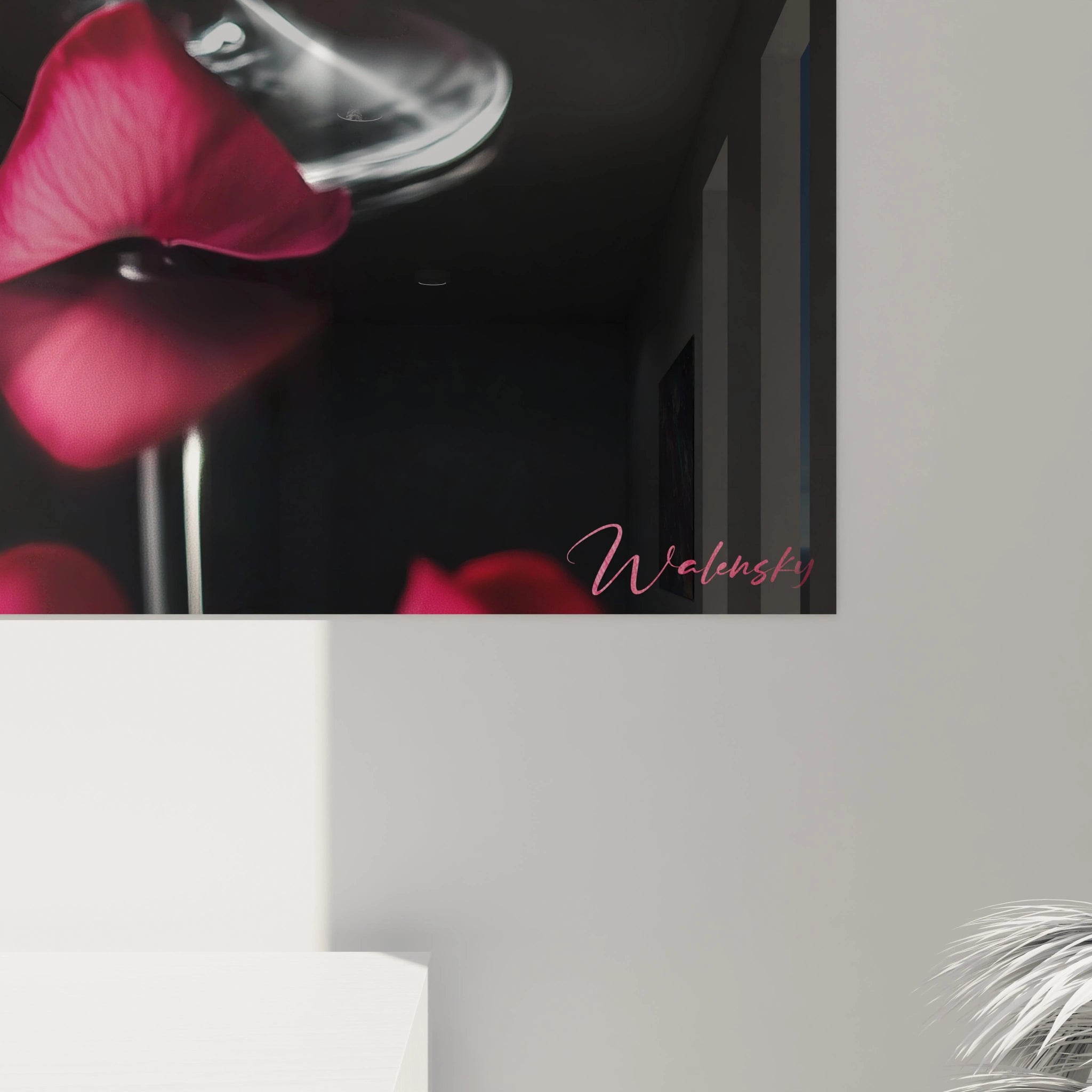 Un tableau cocktail représentant un verre finement ciselé rempli d’un liquide rouge éclatant, avec des pétales posés à la surface. Les contrastes entre le noir du fond et le verre accentuent les textures.