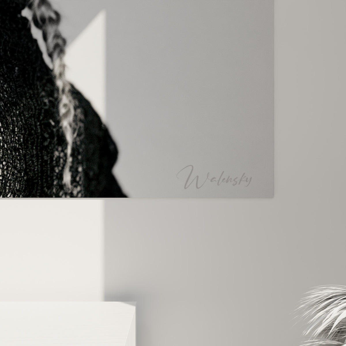 Grain photographique fin sur la tresse grise et la maille noire, jeu de lumière blanche et ombres sculptées