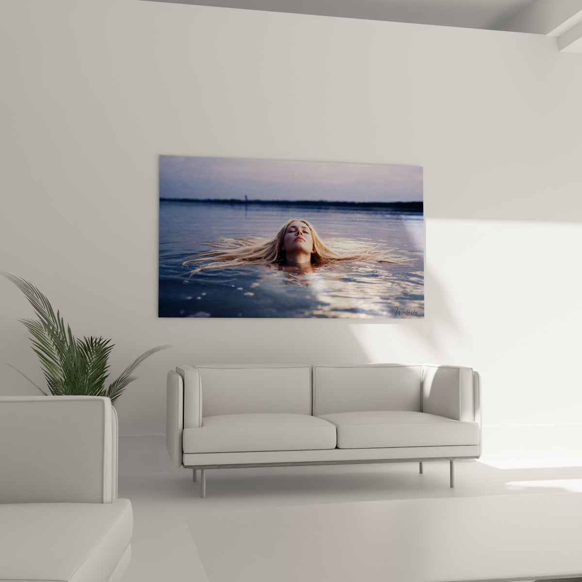 Femme immergée aux mèches blondes rayonnantes sur fond bleu gris, au-dessus d'un canapé dans un salon lumineux