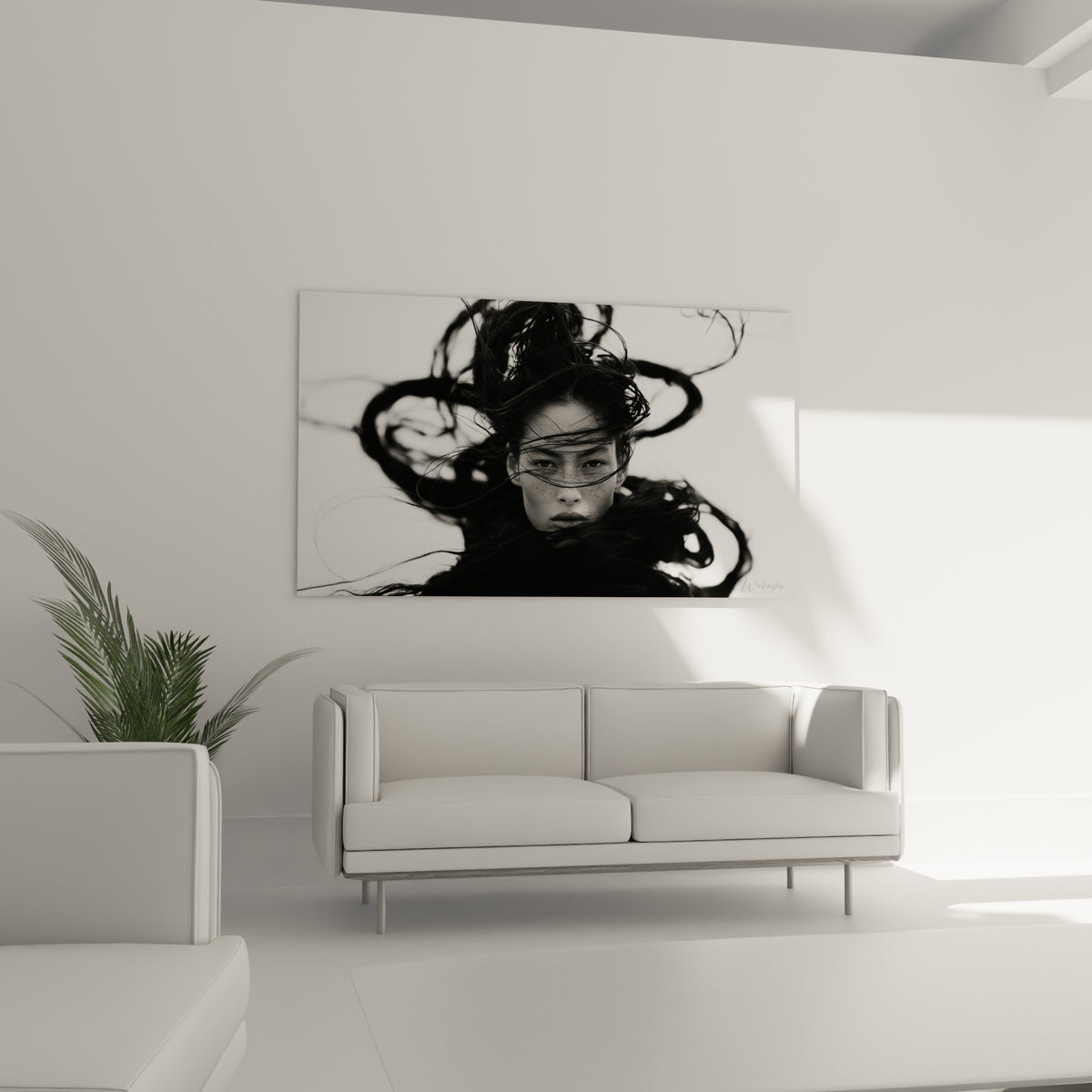 Portrait aux mèches anthracite dessinant des arabesques sur fond blanc, au-dessus d'un canapé dans un salon lumineux