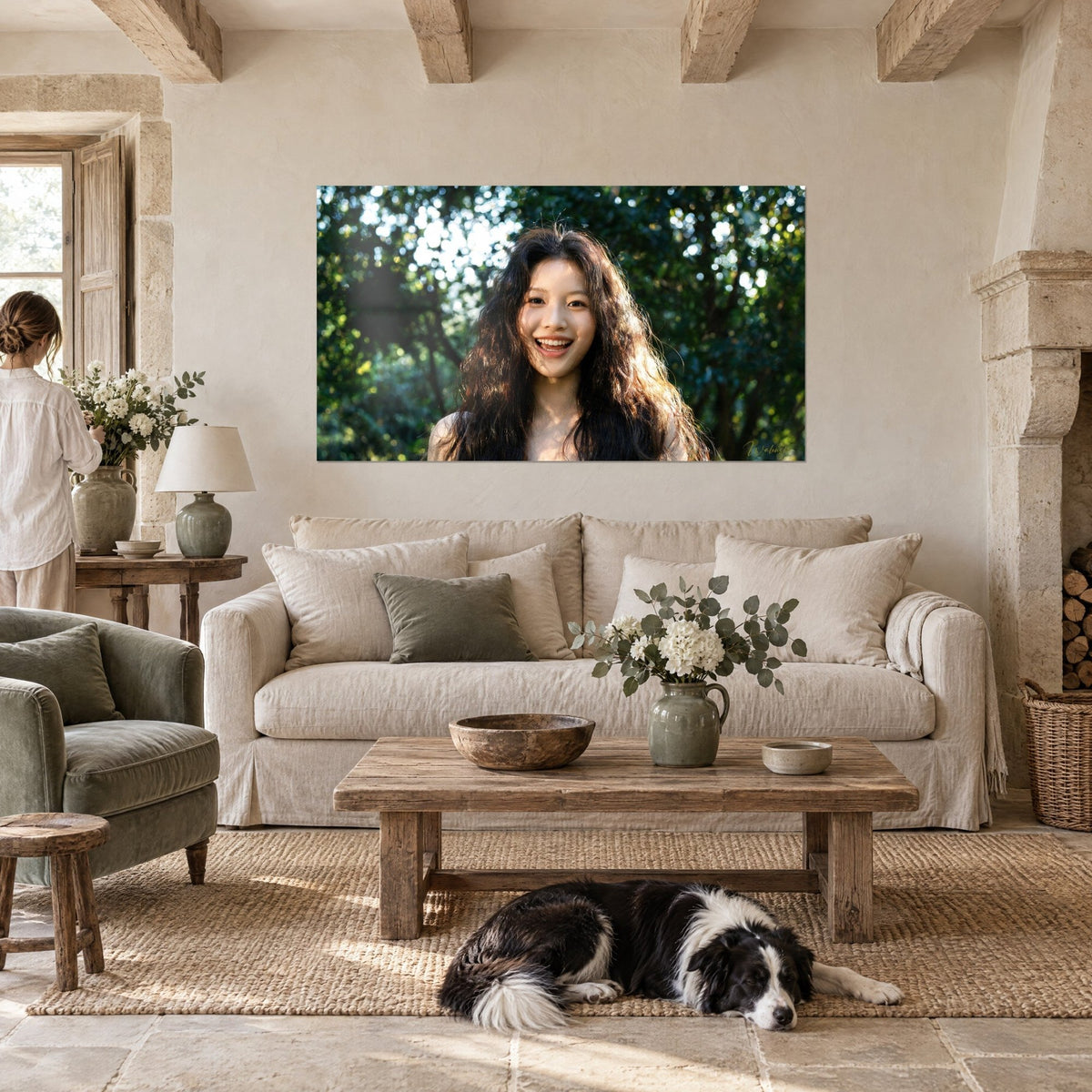 Wall art of a laughing young woman with brown curls, green and ochre foliage backlit, a reclining collie, above a sofa in a bright living room