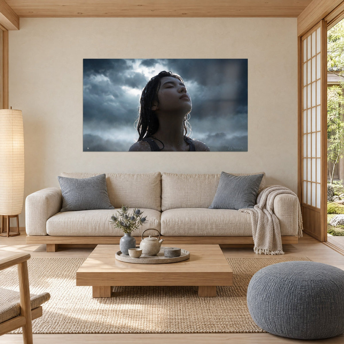 Cuadro mujer con el rostro alzado bajo la lluvia, cabello negro mojado, nubes gris acero y cielo blanco, sobre un sofá en un salón luminoso