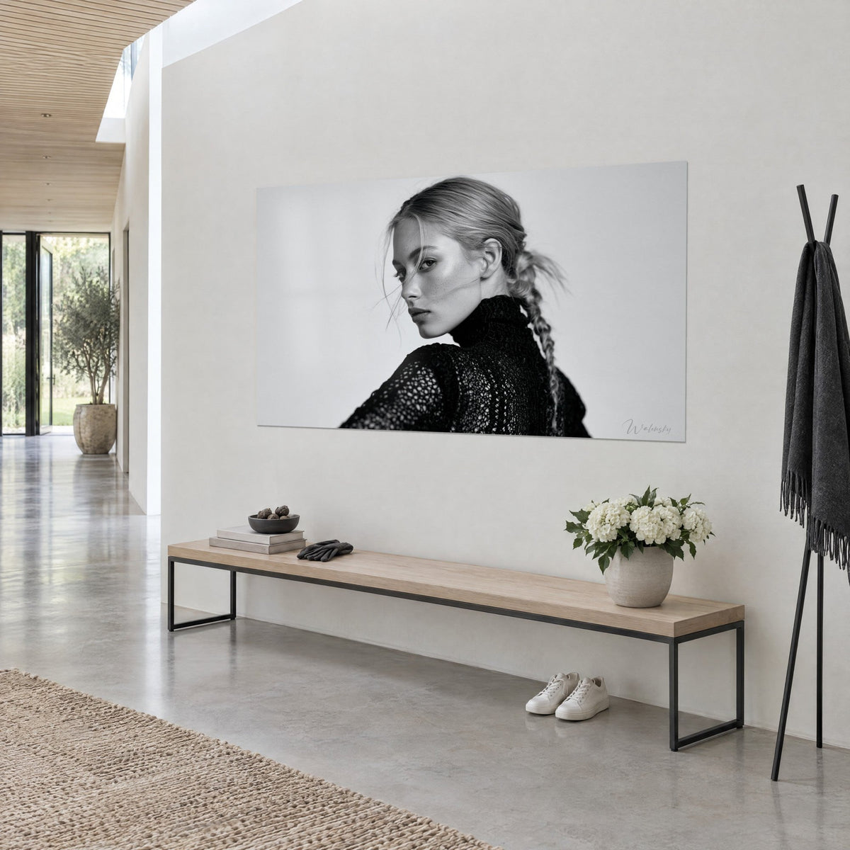 Wall art young woman with a blonde braid and a black openwork turtleneck, pearl grey background, on a white bright hallway wall