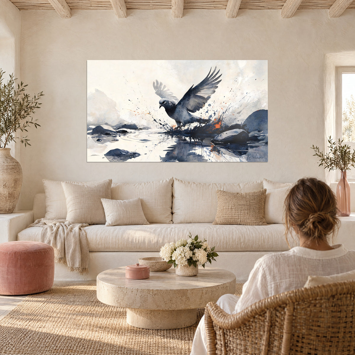 Tableau colombe grise aux ailes déployées, encre bleu nuit et éclats orange, femme de dos, au-dessus d'un canapé dans un salon lumineux