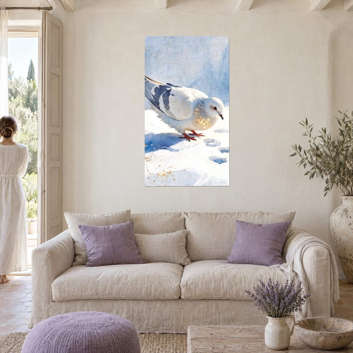 Tableau colombe blanche aux ailes bleu marine, pattes rouges sur la neige, femme de dos, au-dessus d'un canapé dans un salon lumineux