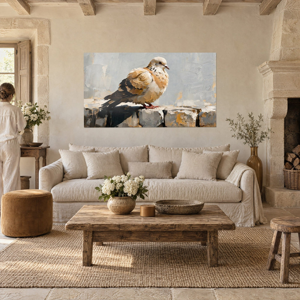 Tableau colombe beige aux ailes crème et brun sombre sur un muret gris, vue par deux personnes de dos, au-dessus d'un canapé dans un salon lumineux