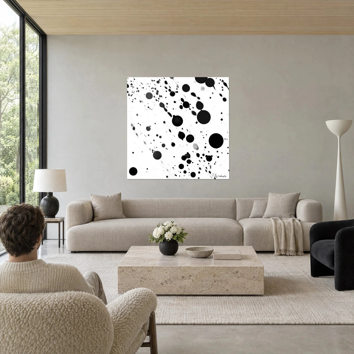 Gemälde mit schwarzen Tintentropfen, die auf weißem Grund spritzen, große Kugeln und feine Schlieren, über einem Sofa in einem hellen Wohnzimmer