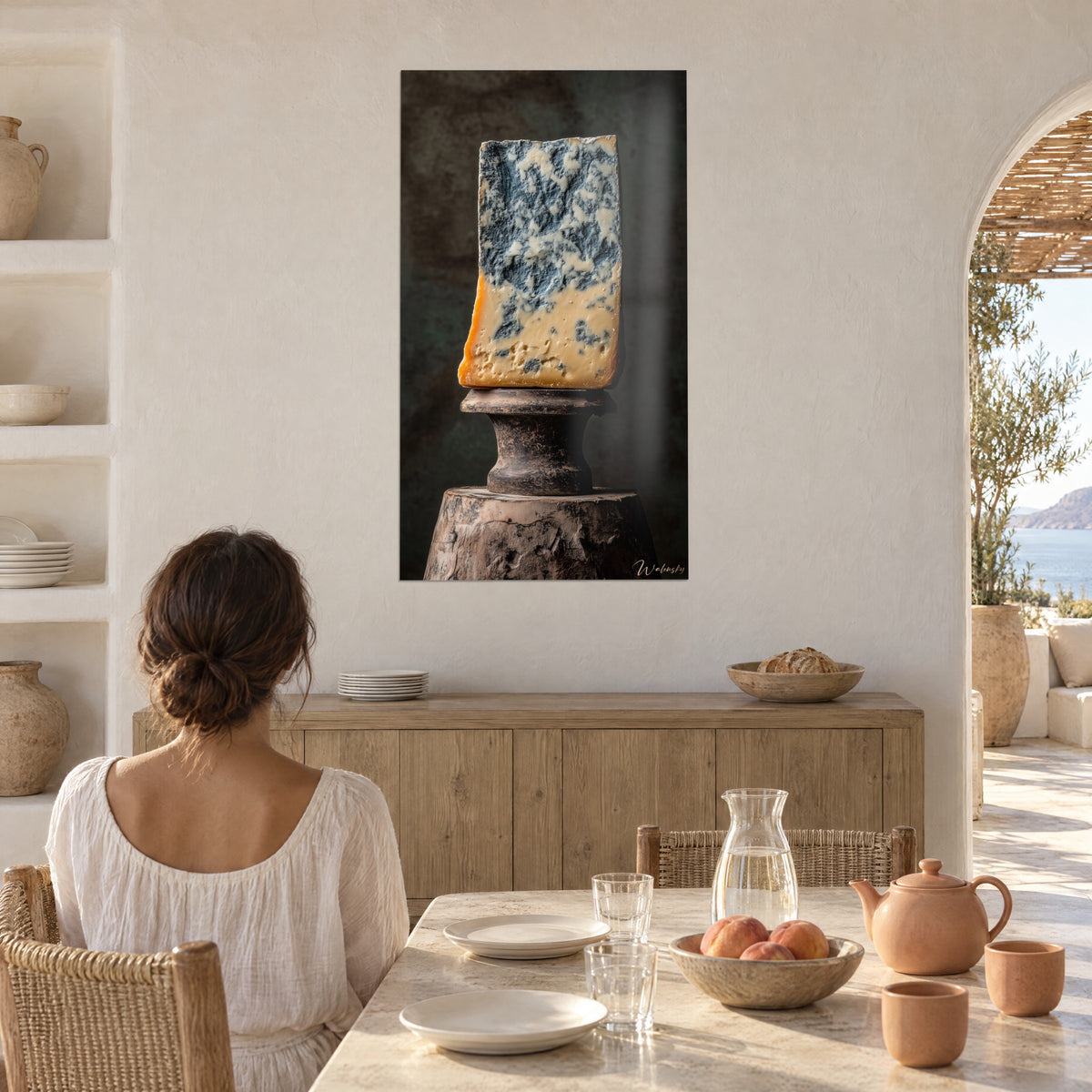 Schilderij blok blauwe kaas, leiblauw en boterkleurig geel, gekalkte muur naast een stenen zomertafel