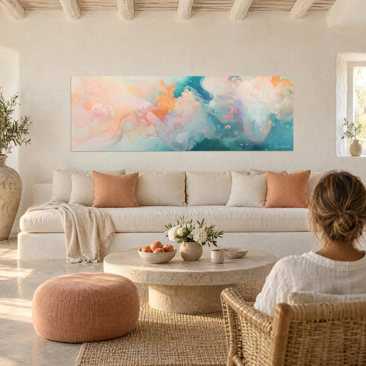 Schilderij zwevende wolken in perzikroze en turquoise, oranje krullen, vrouw met de rug naar de kijker boven een bank in een lichte woonkamer