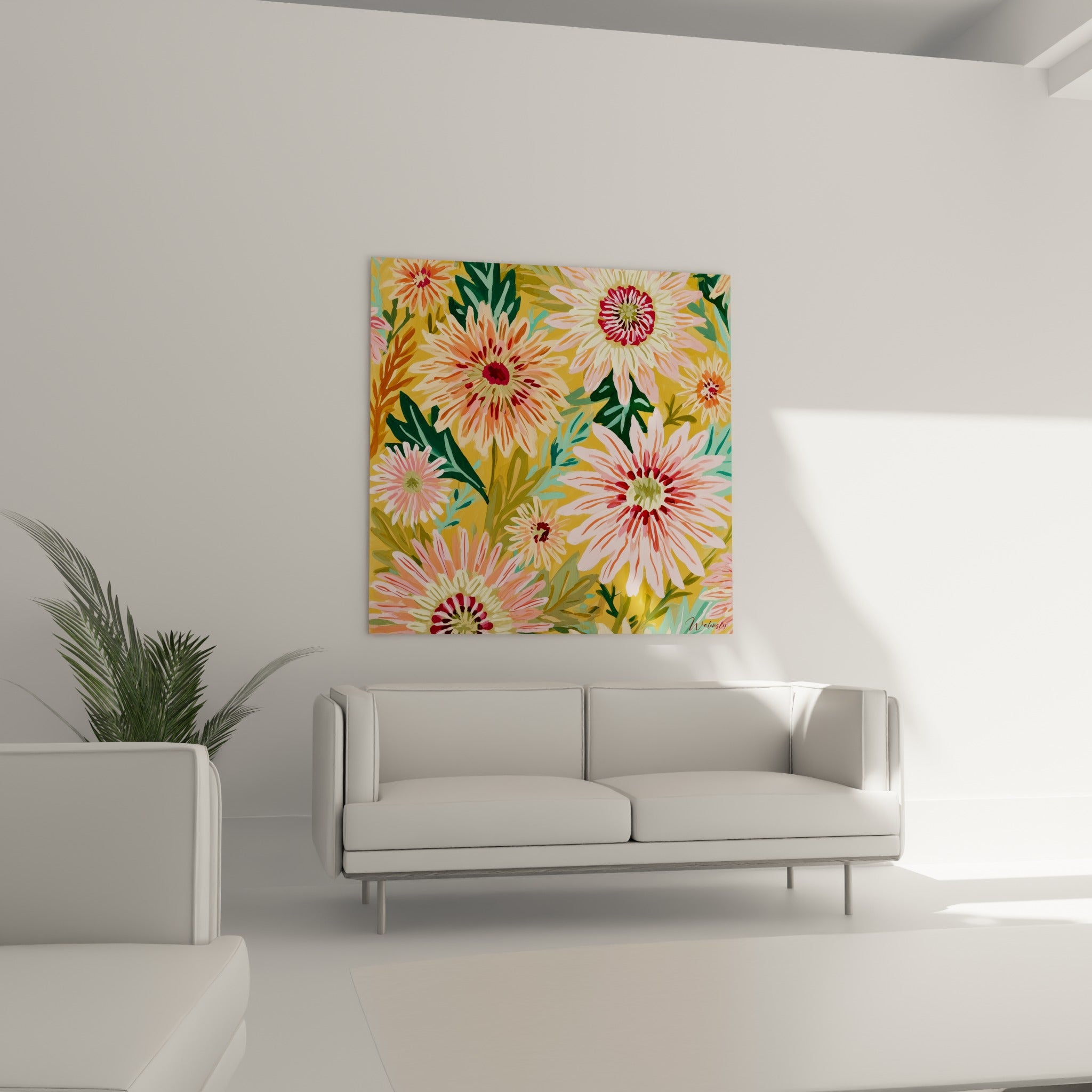 Corolles de dahlias rose poudré et jaune moutarde, au-dessus d'un canapé dans un salon lumineux