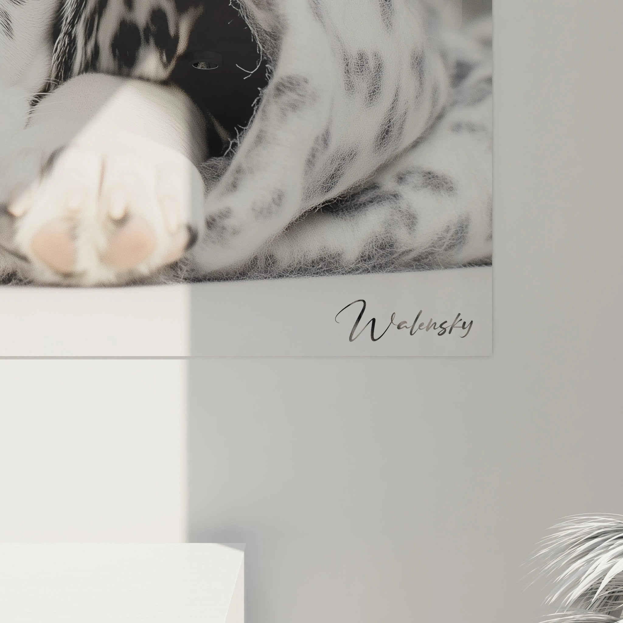 Un tableau dalmatien figurant un chiot au pelage tacheté caractéristique, allongé confortablement avec ses pattes avant visibles, enveloppé dans une couverture à motifs identiques, rendant l'ensemble harmonieux en noir et blanc.