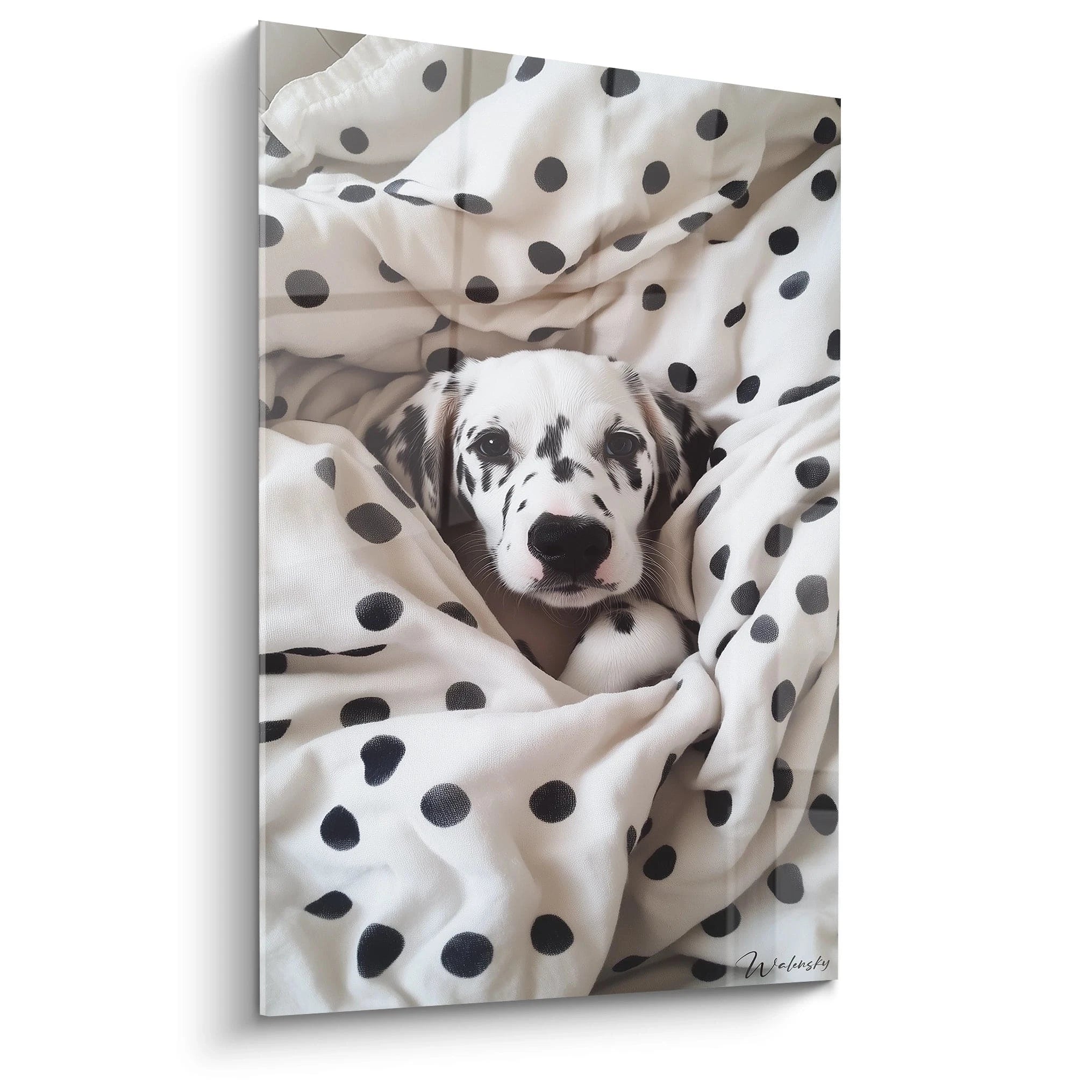 Un tableau dalmatien représentant un chiot à taches noires et blanches, niché dans un tissu à pois assorti. Les contrastes saisissants entre le pelage moucheté et les pois du textile créent une harmonie visuelle parfaite.