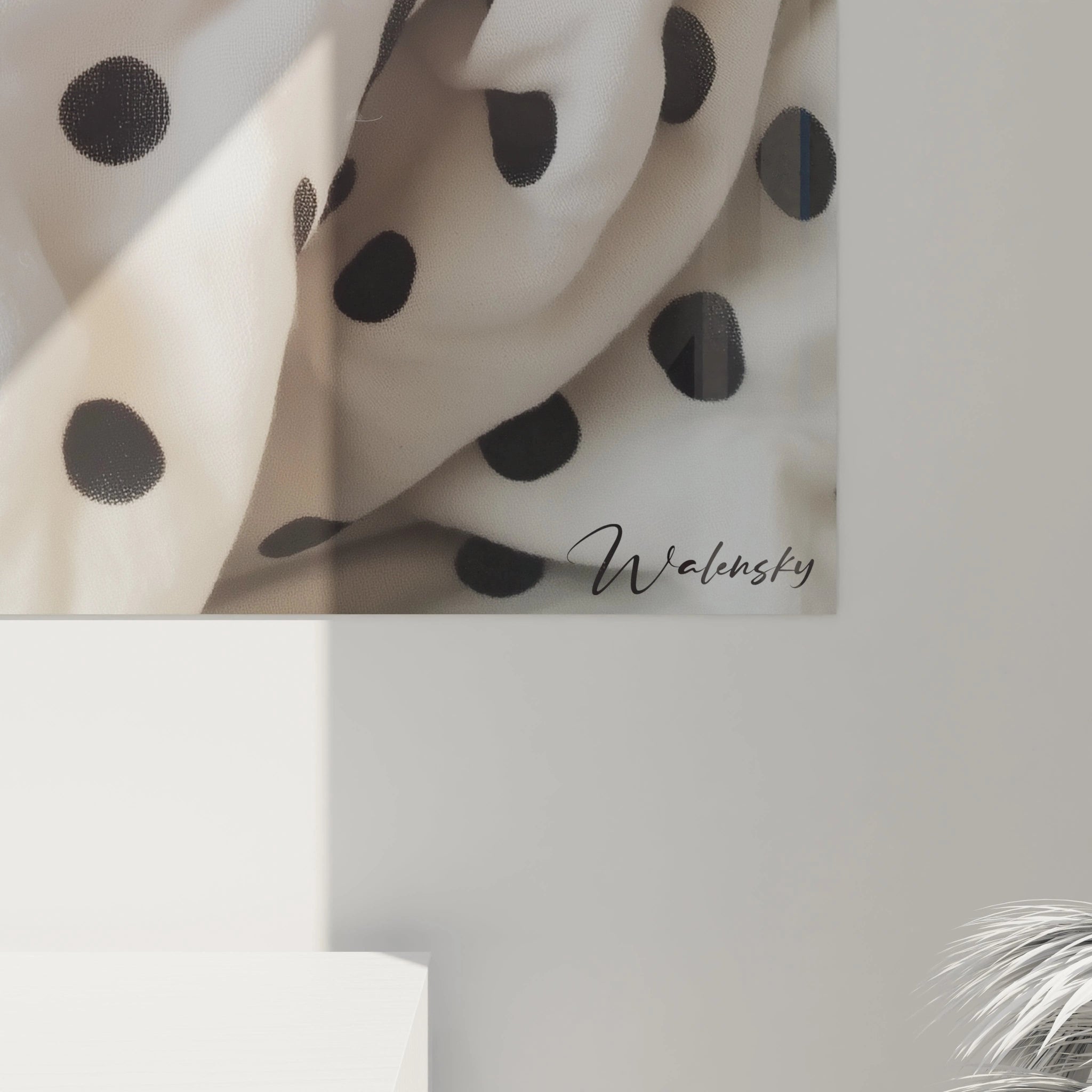 Tableau dalmatien présentant un jeune chien blanc à taches noires, lové dans un tissu aux motifs similaires. La composition centrée met en valeur les yeux noirs brillants et le museau rose du chiot sur fond de textile plissé.