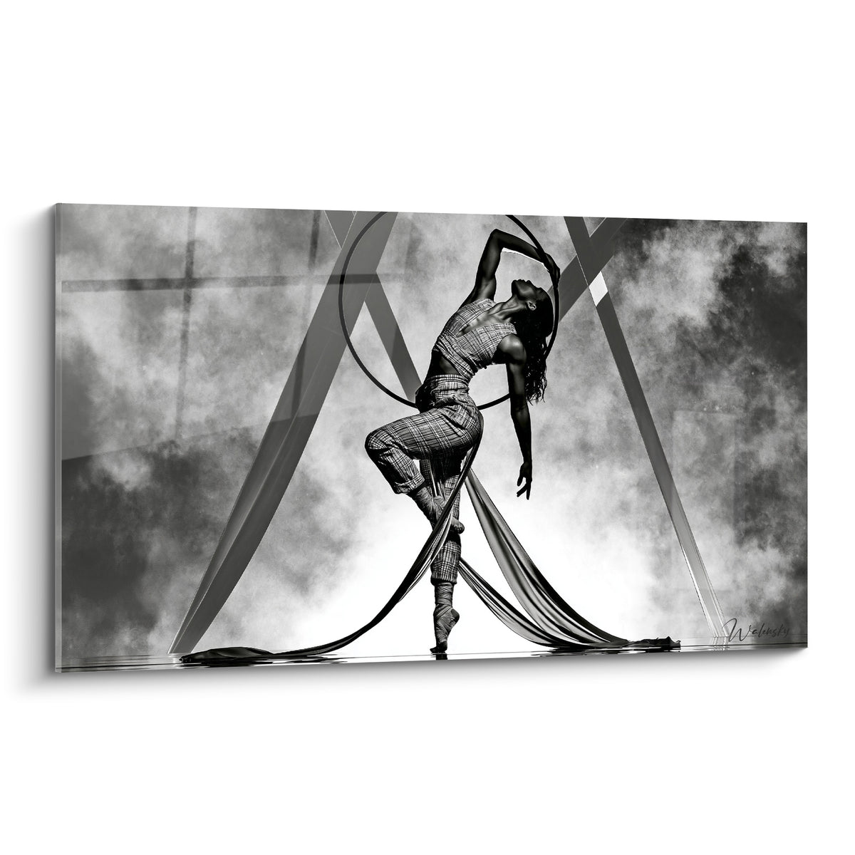 Danse acrobatique : performeuse cambrée en noir et blanc, cerceau levé, voiles gris fumé au sol