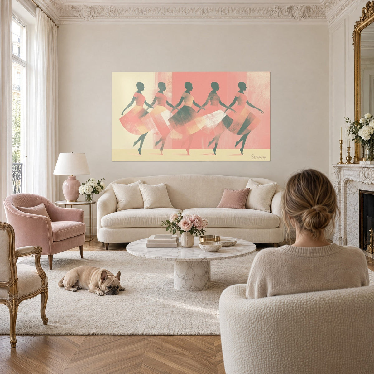 Tableau cinq danseuses stylisées en jupes corail et crème sur fond rose, bulldog couché, au-dessus d'un canapé dans un salon lumineux