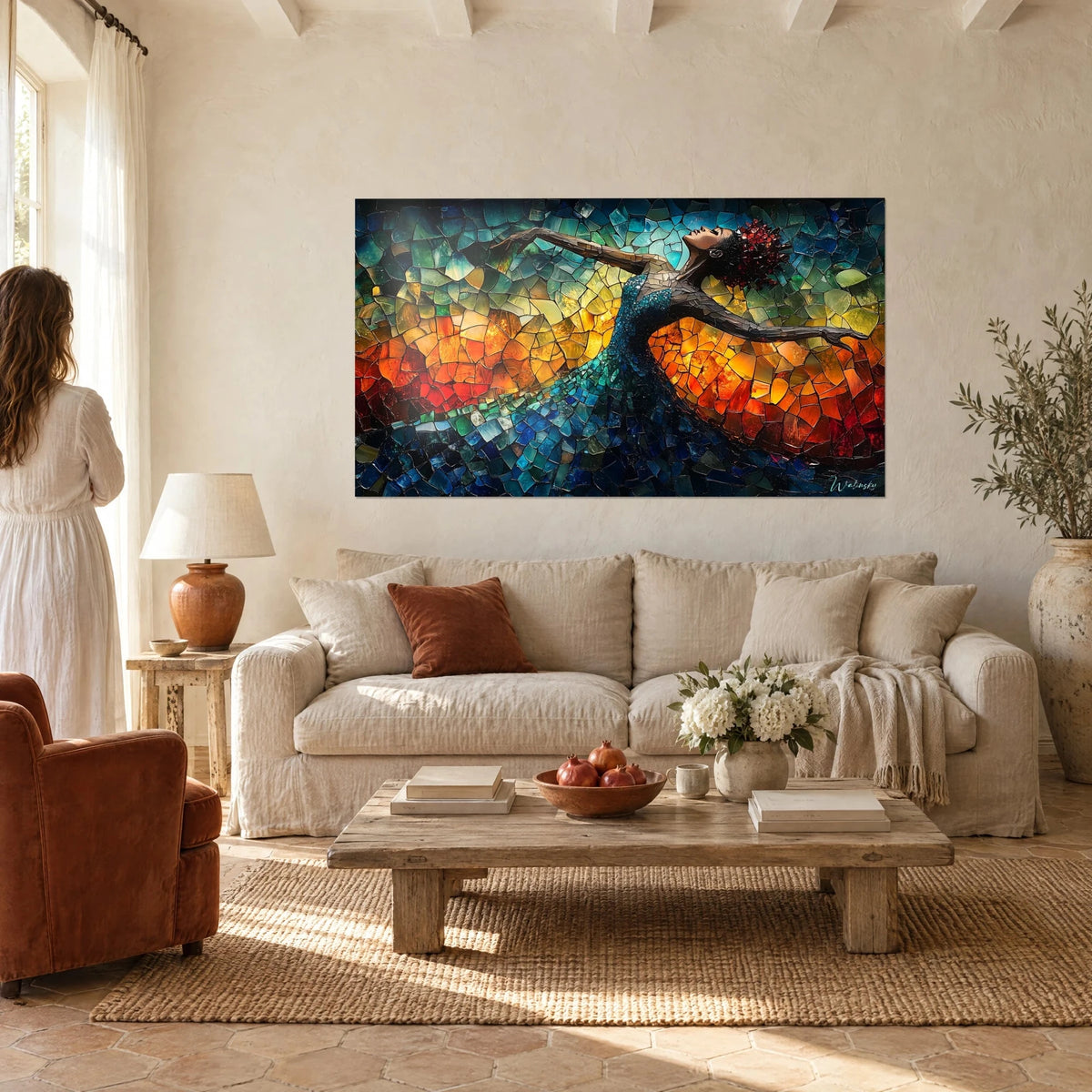 Wall art of a dancer in glass mosaic, arms outstretched, turquoise blue dress against a blazing orange background, above a sofa in a bright living room