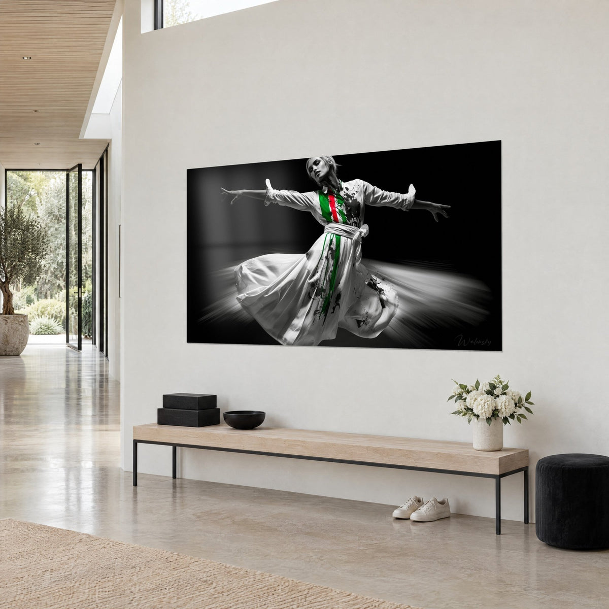 Tableau derviche en noir et blanc, jupe ample floue et coulures vert vif et rouge, vue de trois-quarts sur un mur crème