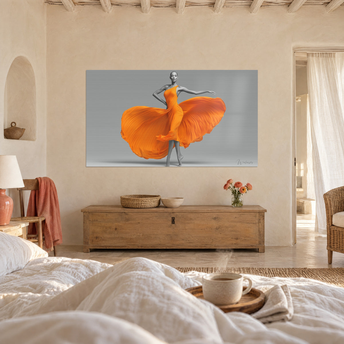 Cuadro maniquí con vestido asimétrico naranja, falda hinchada como un pétalo, fondo gris claro, frente a una cama de lino blanco, encima de una cama en un dormitorio luminoso