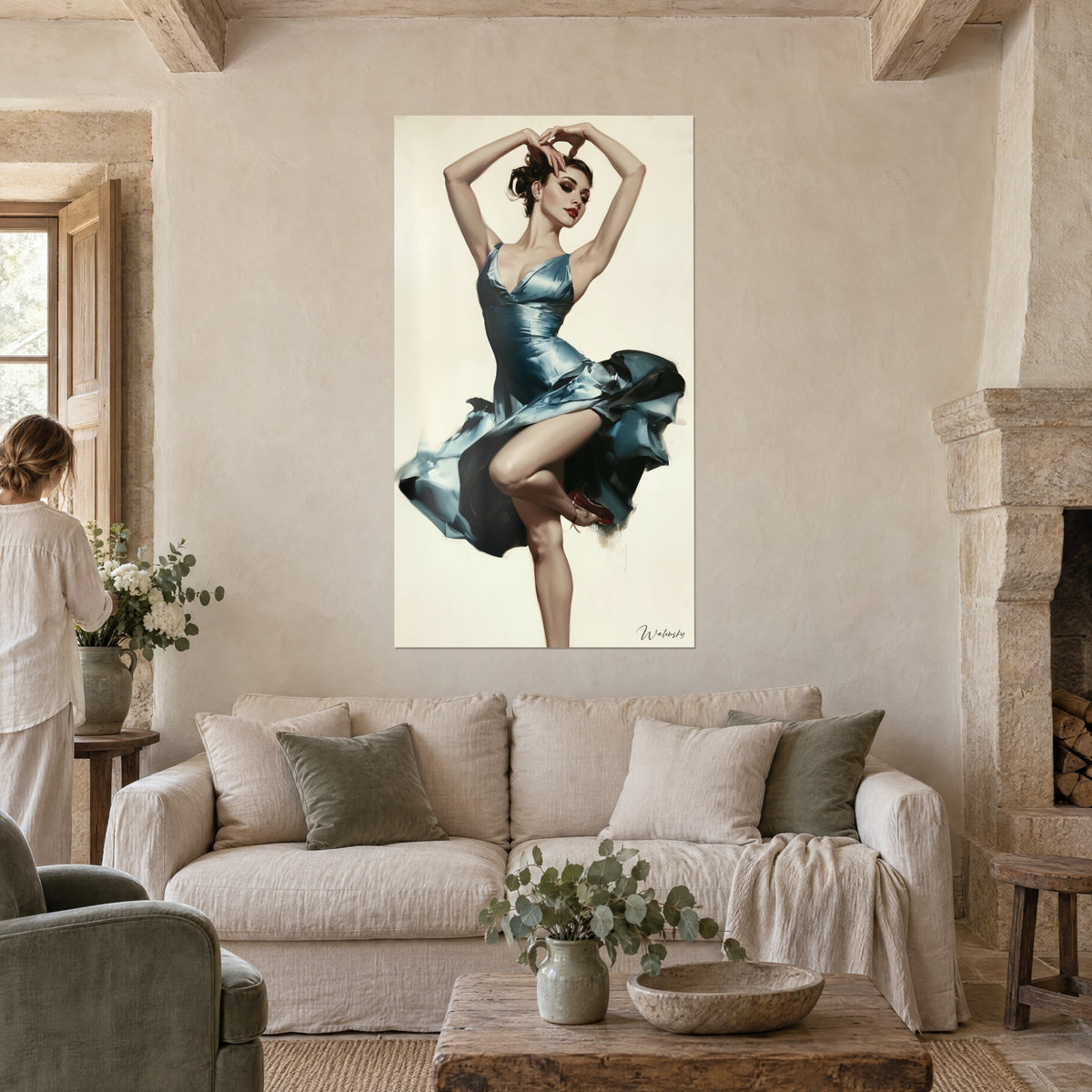 Πίνακας χορεύτρια με σατέν φόρεμα χρώματος ατσαλί μπλε, με τα χέρια ψηλά σε κρεμώδες φόντο, δύο άτομα από πίσω, πάνω από καναπέ σε φωτεινό σαλόνι