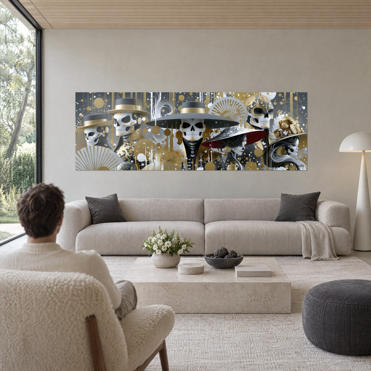 Quadro di teschi con cappelli grigi e dorati tra ventagli aperti, due persone di spalle, sopra un divano in un soggiorno luminoso