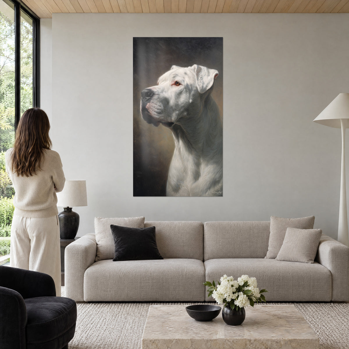 Wall art white Dogo Argentino in profile, amber eye, dark brown background, woman seen from behind, above a sofa in a bright living room
