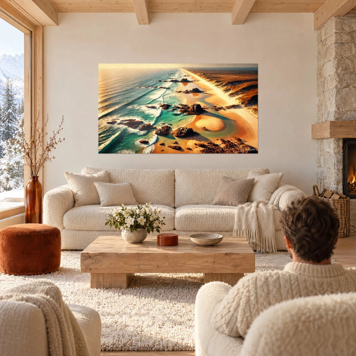 Wall art wild coastline seen from above, brown rocks, turquoise sea and apricot sand, above a sofa in a bright living room
