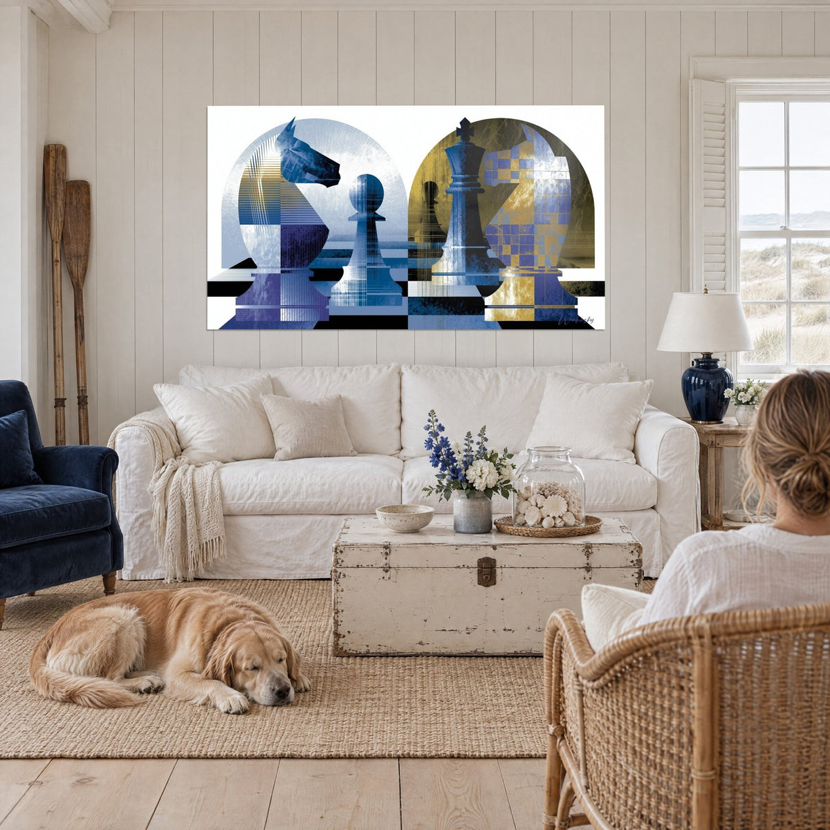Schilderij schaakpaarden in blauw en goud met geometrische bogen, liggende retriever, boven een bank in een lichte woonkamer