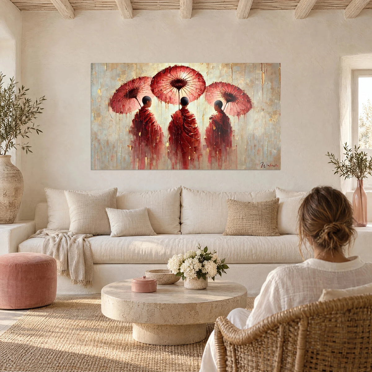 Tableau trois jeunes moines aux robes rouge carmin et ombrelles roses, fond crème coulant, au-dessus d'un canapé dans un salon lumineux