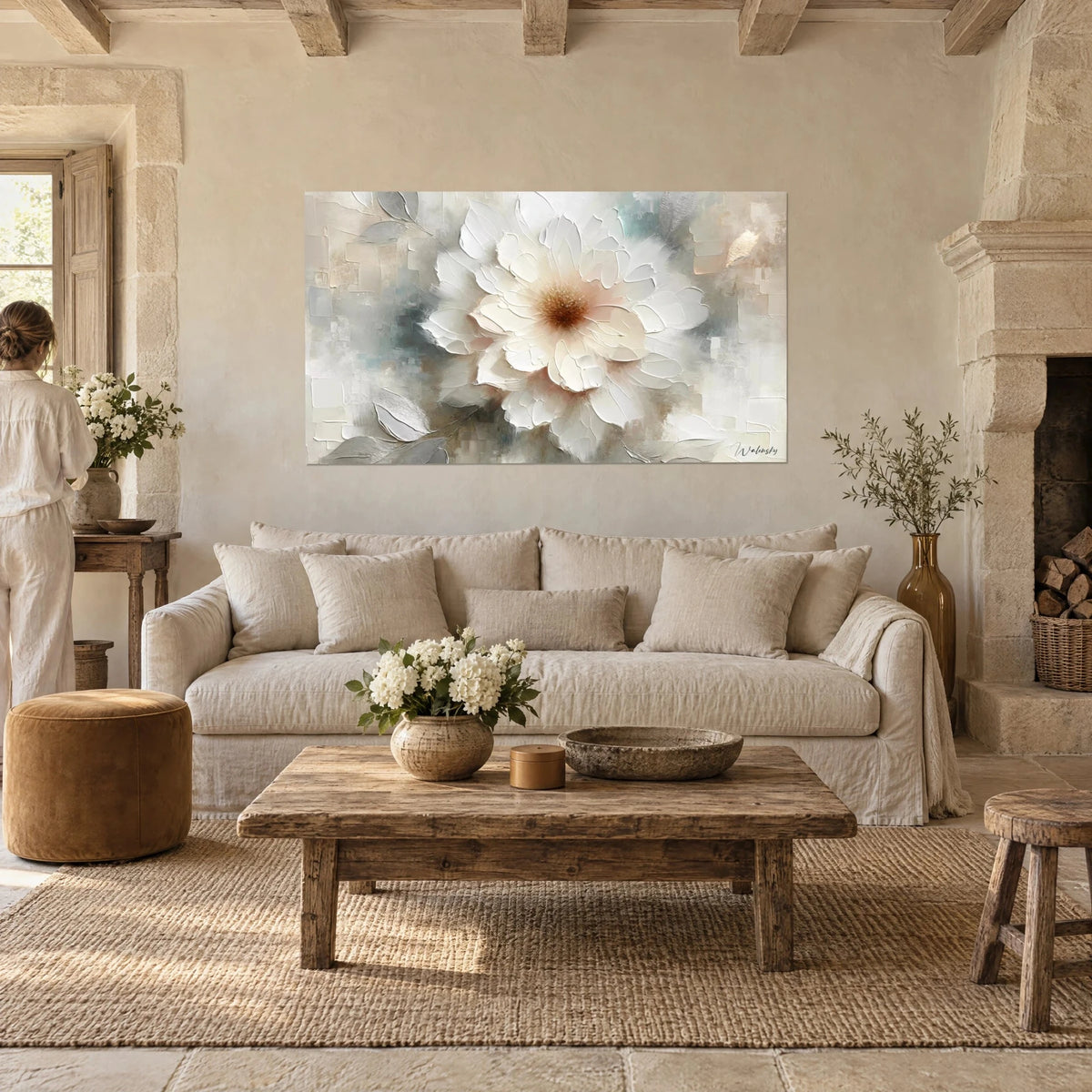 Wall art cream peony with thick painted petals, grey-blue and ivory tones, woman seen from behind, above a sofa in a bright living room