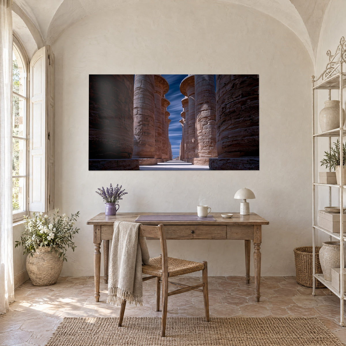 Schilderij perspectief van reusachtige gebeeldhouwde zuilen, roze oker en diepblauw, boven een houten bureau in een Provençaalse mas