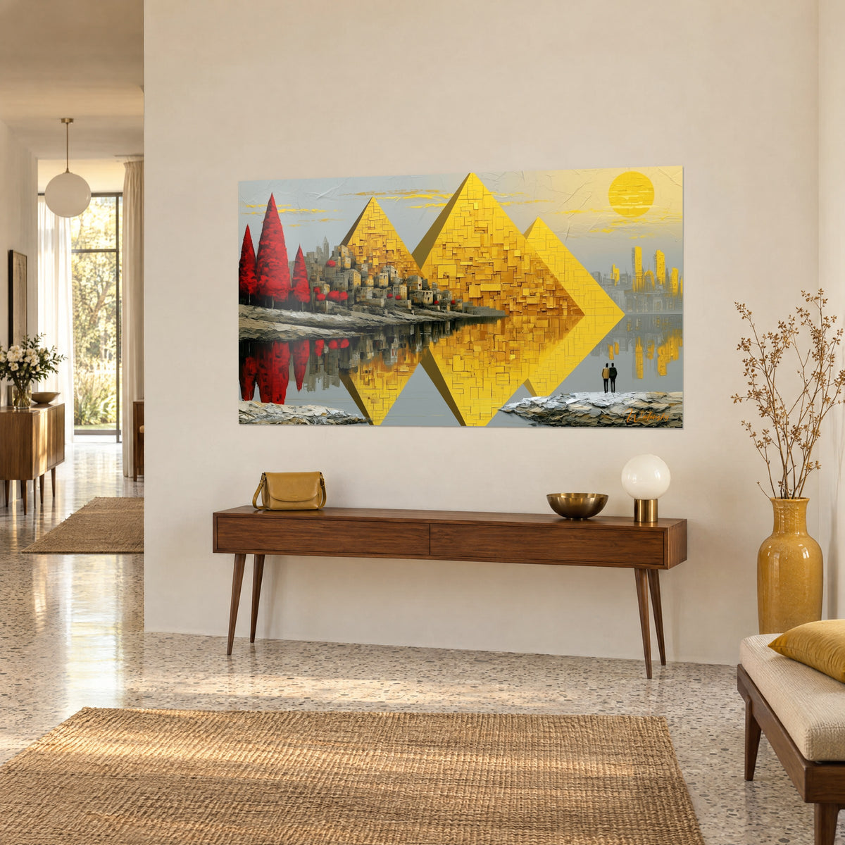Wall art triptych of mustard yellow pyramids, bright red cypresses and a golden city reflected, on a beige wall beside a console table