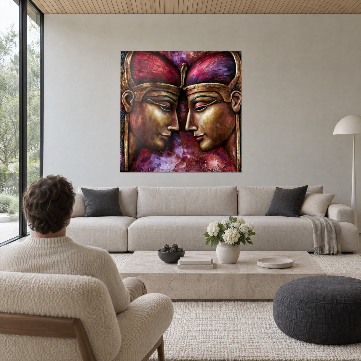 Wall art two golden pharaohs facing each other, crimson and fuchsia headdresses, central golden serpent, above a sofa in a bright living room