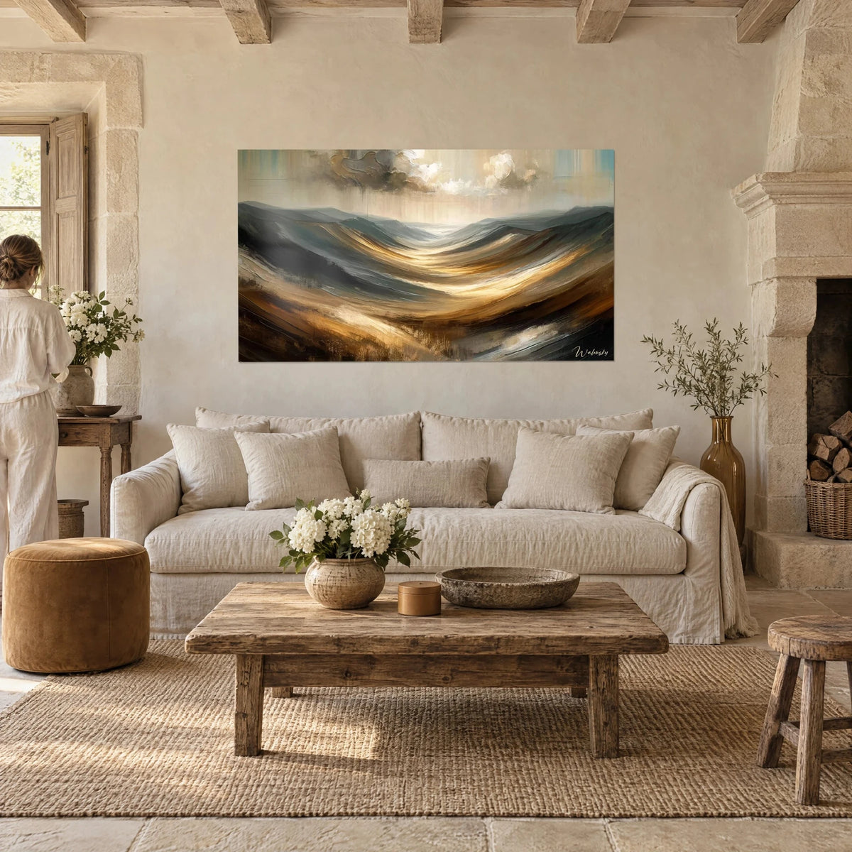 Wall art rolling hills swept by wind, gilded ochre and slate grey, cream cloudy sky, above a sofa in a bright living room