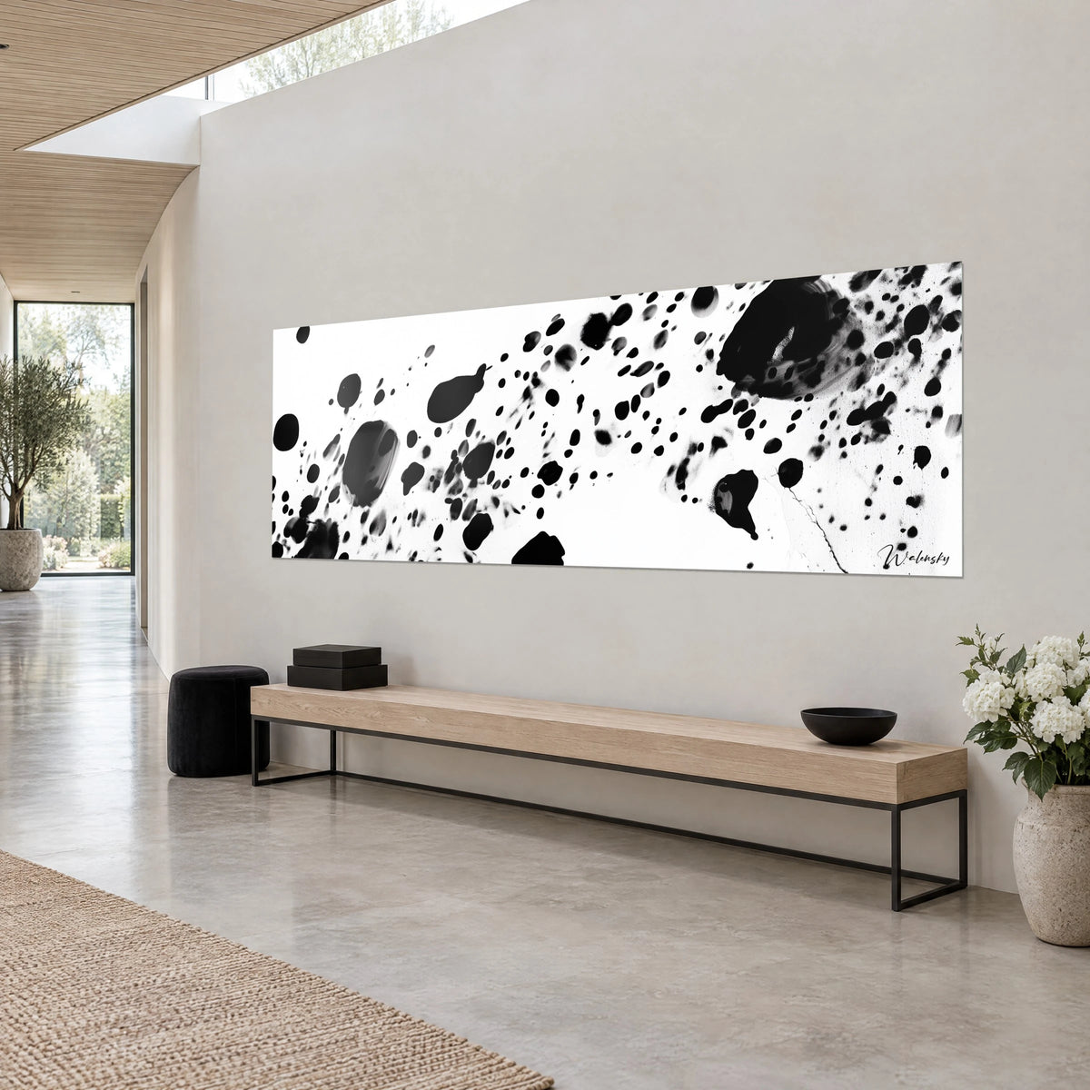 Quadro panoramico di gocce di inchiostro nero spruzzate su carta bianco crema, visto di tre quarti, su una parete beige grigia