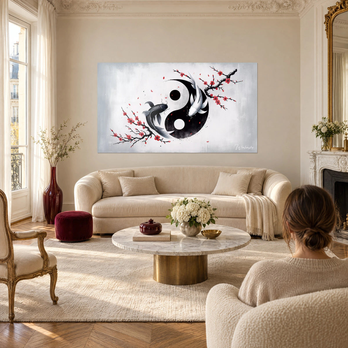 Tableau yin-yang de deux carpes koï, l'une noire, l'autre blanche, branches de cerisier rouges, au-dessus d'un canapé dans un salon lumineux
