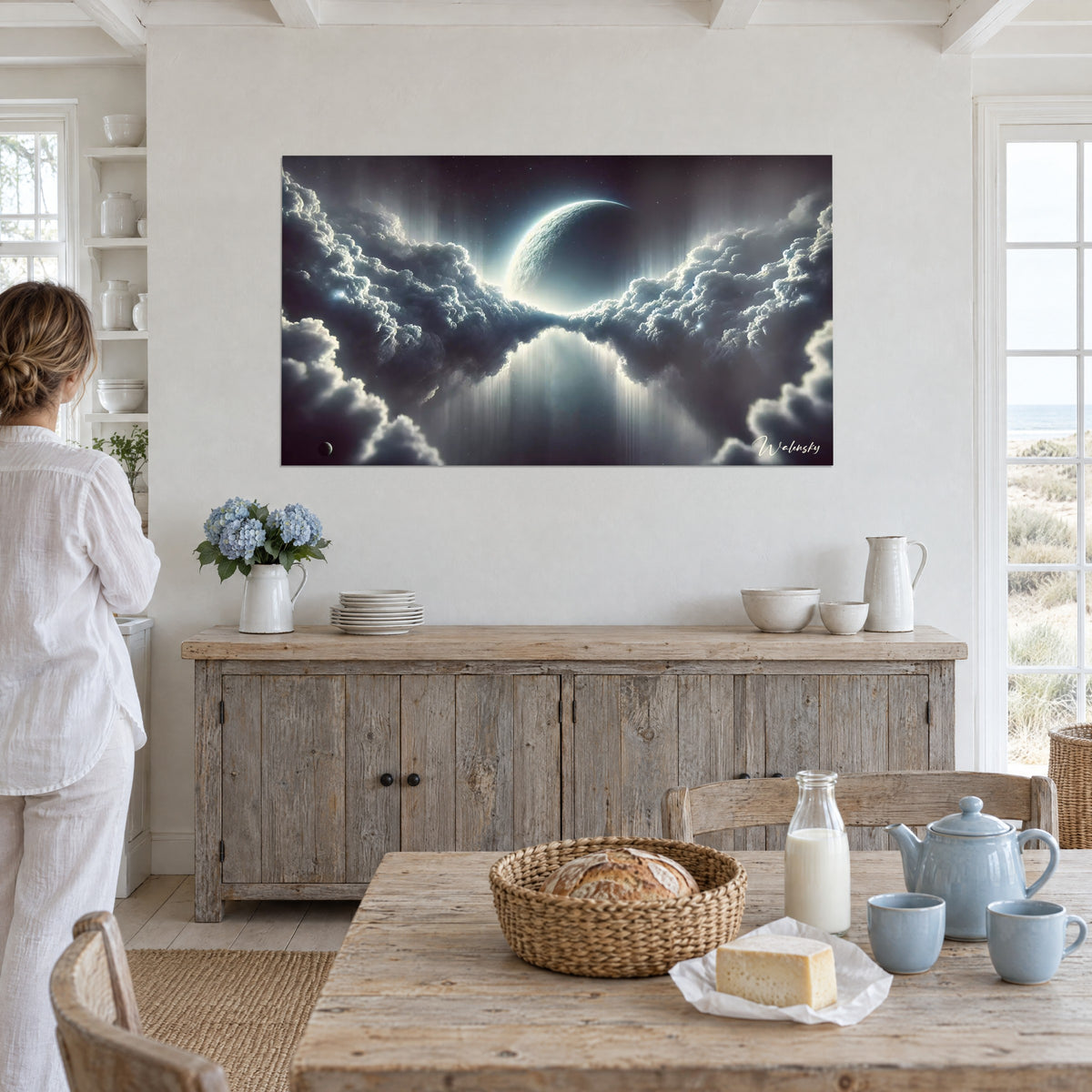 Wall art celestial vault where an icy blue crescent moon pierces dark cumulus clouds, white wall in front of a farmhouse table