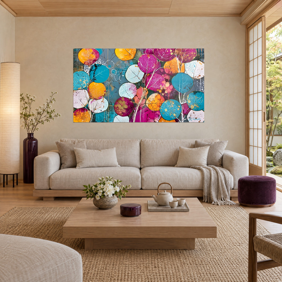 Schilderij met ronde turquoise en magentakleurige bladeren, oranje gespikkeld, op een blauwgrijze achtergrond, boven een bank in een lichte woonkamer