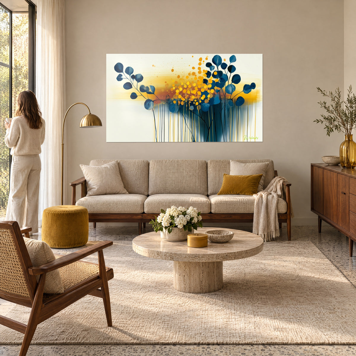 Tableau feuilles d'eucalyptus bleu marine, pointillés jaune safran suspendus sur fond crème, au-dessus d'un canapé dans un salon lumineux