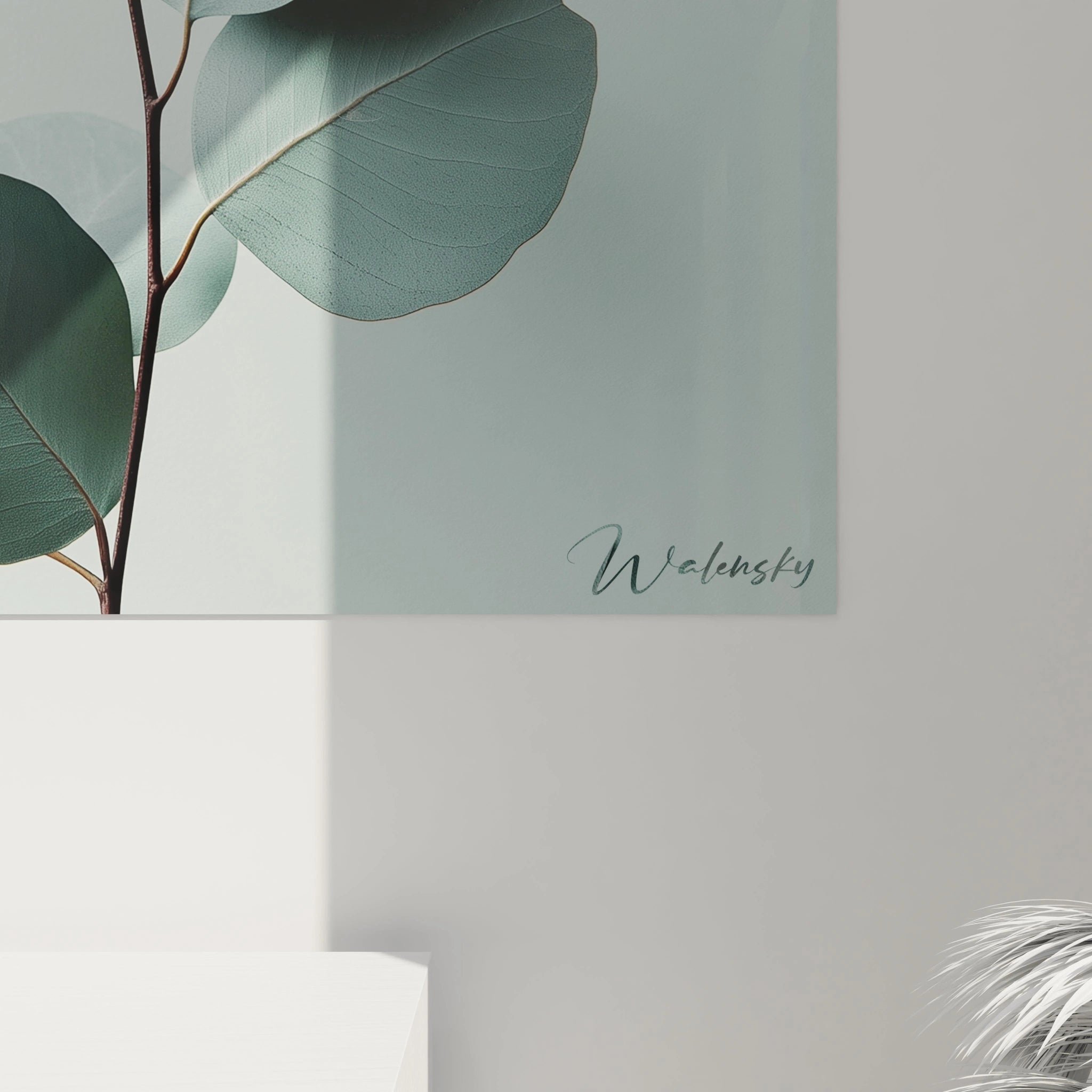 Un tableau Eucalyptus nature représentant des feuilles aux tons verts et gris délicatement superposées. Le fond blanc légÚrement texturé accentue le contraste et la finesse des contours des feuilles.